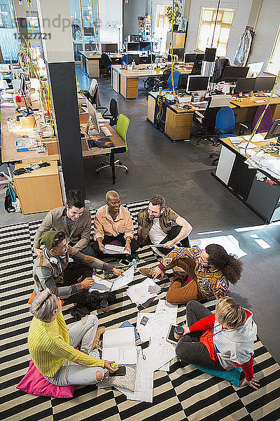 Creative business team meeting  brainstorming in circle on office floor