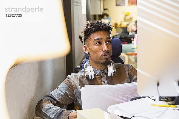 Focused creative businessman working at computer in office