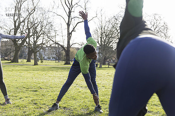Man stretching  exercising in park