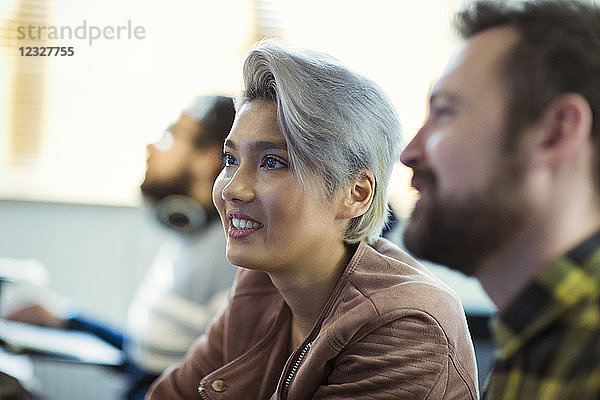 Smiling creative businesswoman listening in meeting