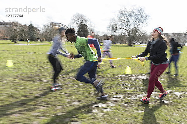 People racing  doing team building exercise in sunny park