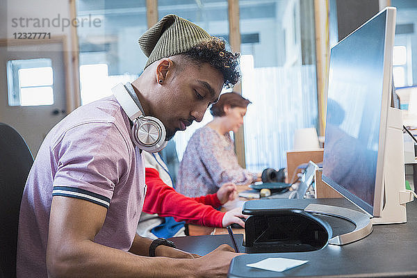 Focused creative businessman working at computer in office