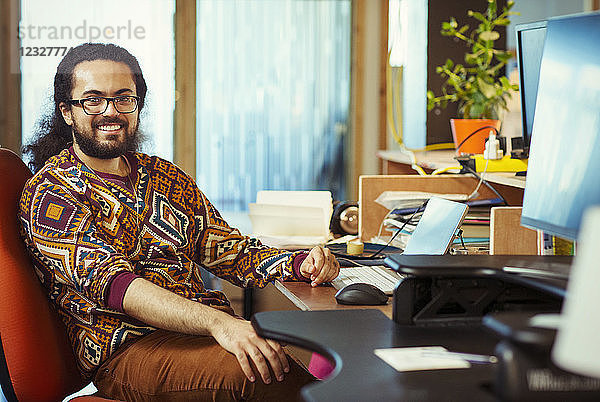 Portrait smiling  confident creative businessman working at desk