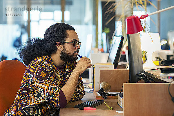 Focused creative businessman working at computer in office