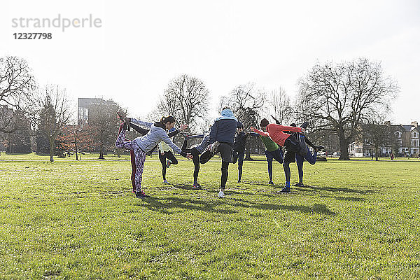 People exercising  stretching in sunny park