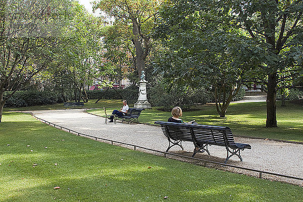 Frankreich  Paris  Luxemburg-Garten  eine Frau und ein Mann lesen auf einer Bank ein Buch.