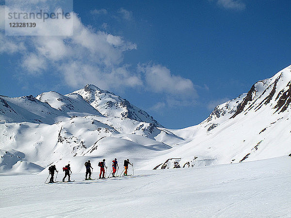 ÖSTERREICH  Tirol  Silvrettagebirge  eine Gruppe von 6 Langläufern in Indianerfeile wandert in Richtung Larainfernerspitze