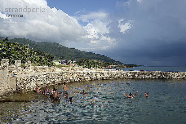 Kuba  Region Santiago de Cuba  einige kubanische Touristen genießen das Meer in einem künstlich angelegten Pool in Chivirico