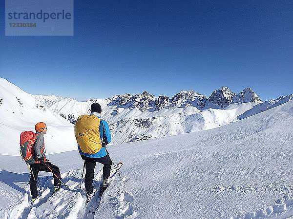 Österreich  Tirol  Sellraintal  2 Männer auf Langlaufskiern posieren vor dem Kalkkögelgebirge am Schafkogelpass