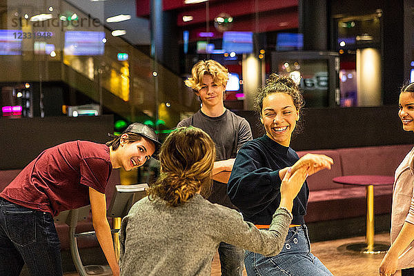 Happy multi-ethnic teenagers enjoying at bowling alley