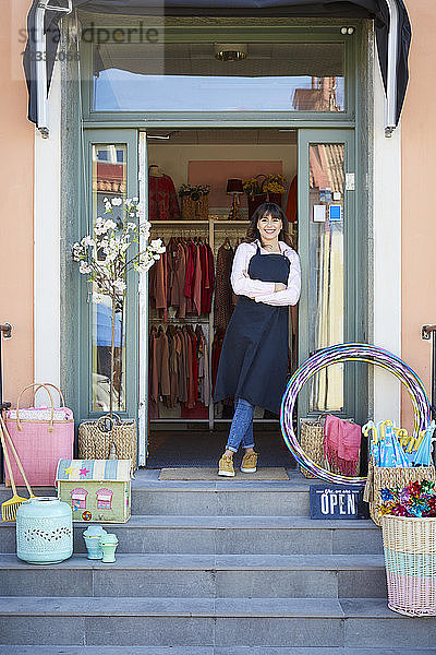 Female owner standing at entrance of boutique