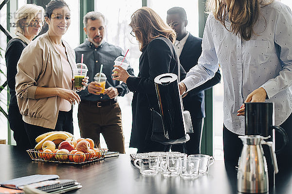 Business people having drinks and fruits during conference in office