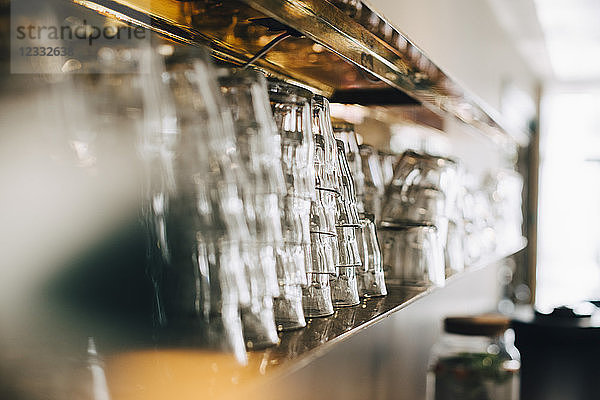 Stack of drinking glasses on shelf in office canteen