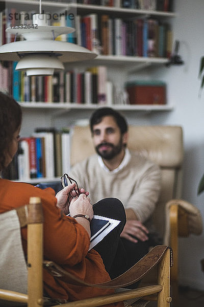 Female therapist with male patient during therapy session at home office