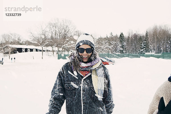 Portrait of mid adult woman standing on snow covered field