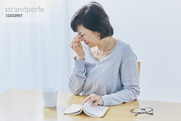 Japanische Seniorin mit Kopfschmerzen