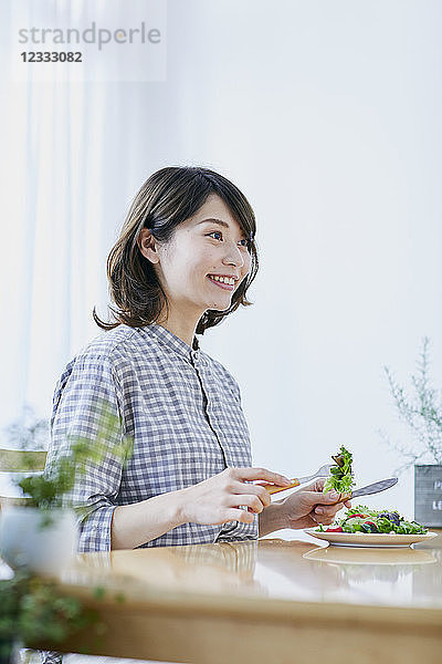 Junge Japanerin isst Salat