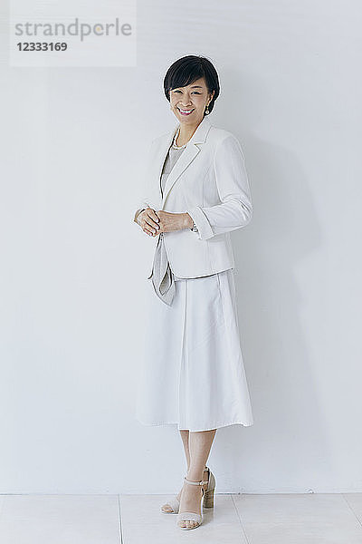 Japanische ältere Geschäftsfrau vor weißer Wand