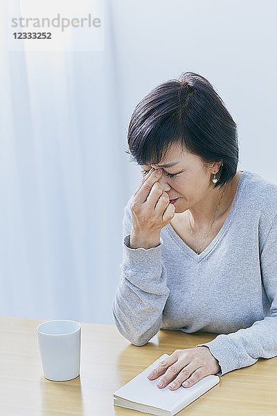 Japanische Seniorin mit Kopfschmerzen