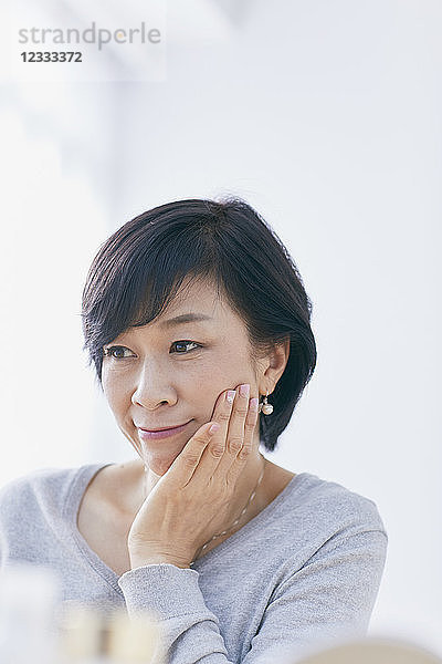 Japanische Seniorin bei der Hautpflege