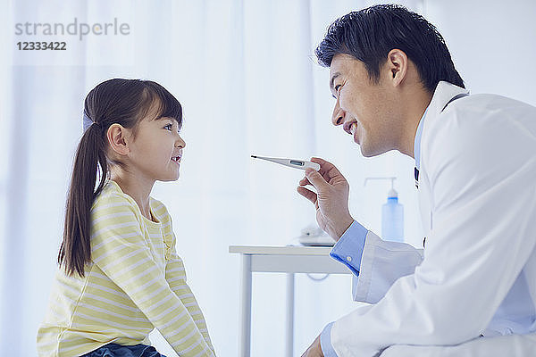 Japanischer Arzt mit einem Patienten in seinem Studio