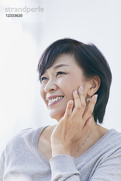 Japanische Seniorin bei der Hautpflege