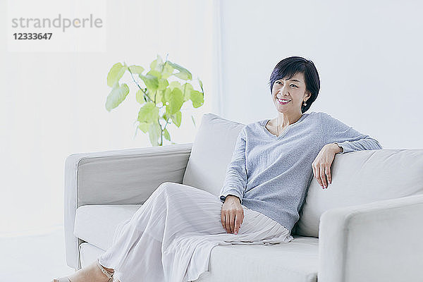 Japanische Seniorin auf Sofa