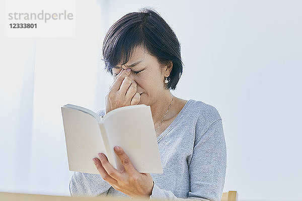 Japanische Seniorin mit Kopfschmerzen