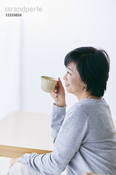 Japanische Seniorin beim Kaffee trinken