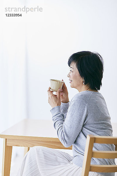 Japanische Seniorin beim Kaffee trinken