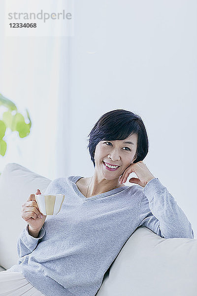 Japanische Seniorin auf Sofa