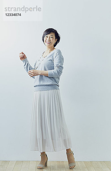 Japanische ältere Frau vor weißer Wand