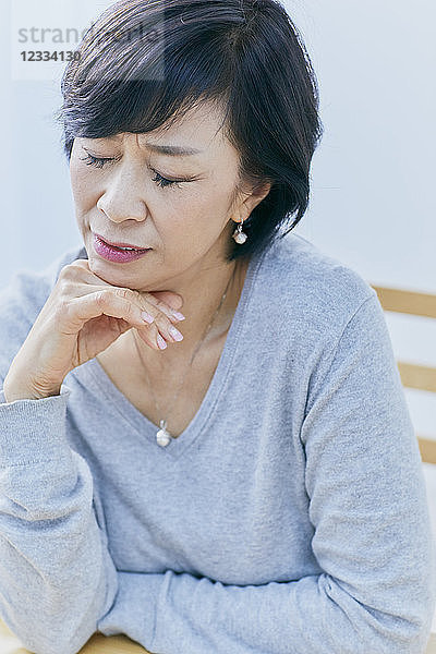 Japanische Seniorin mit Kopfschmerzen