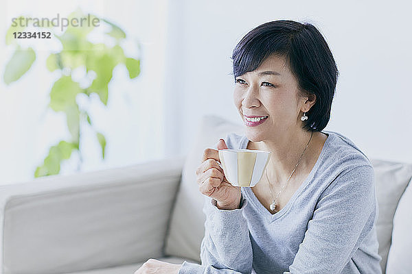 Japanische Seniorin auf Sofa