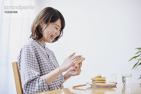 Junge Japanerin isst Pfannkuchen