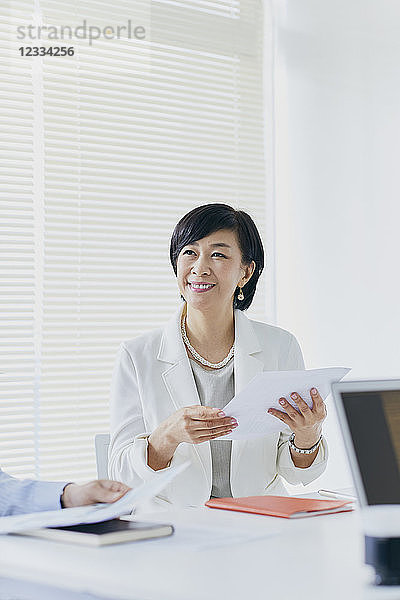 Japanische Senior-Geschäftsfrau bei einer Besprechung im Büro