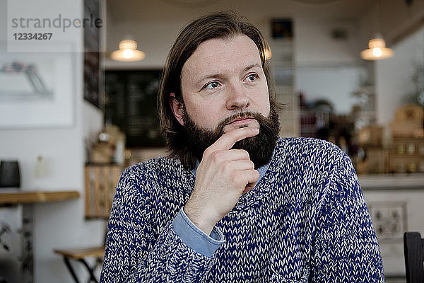 Man with beard sitting in cafe  portrait