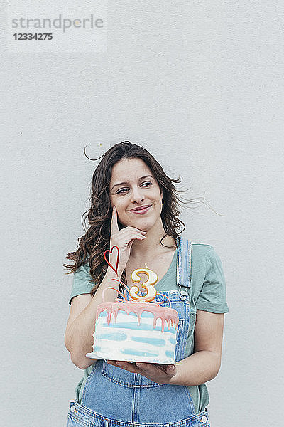 Portrait of smiling woman presenting Birthday cake