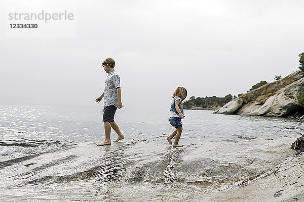 Greece  Chalkidiki  brother and little sister playing together on the beach