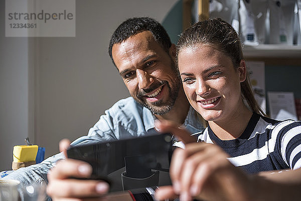 Happy couple taking a selfie in a cafe