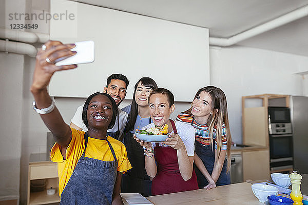 Friends and instructor in a cooking workshop taking a selfie