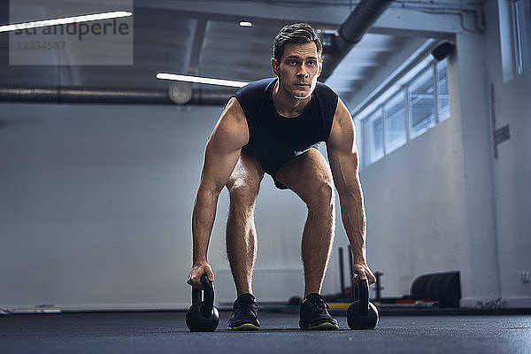 Man doing kettlebell exercise at gym