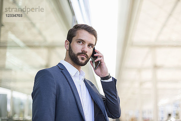 Young businessman on cell phone looking sideways