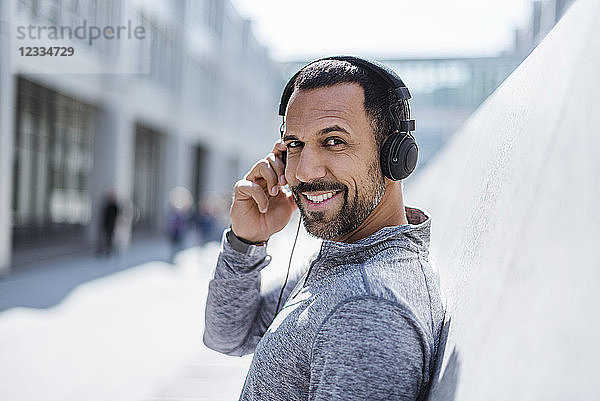 Portrait of smiling man having a break from exercising wearing headphones