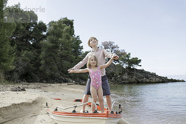 Brother and little sister playing together on the beach