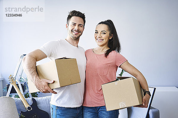 Portrait of happy couple moving in