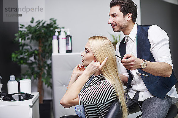 Woman talking to hairdresser in hair salon