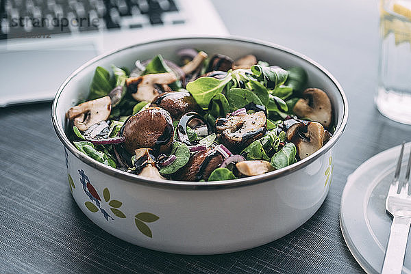 Lunch box with field salad  onions  roasted mushrooms  onions and balsamico