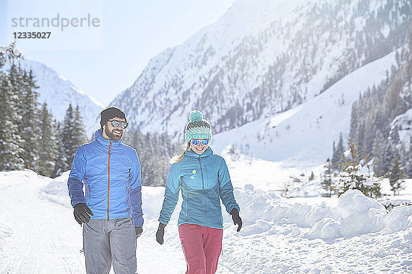 Couple walking in snow-covered landscape
