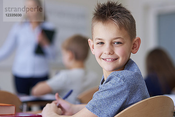Portrait of smiling schoolboy in class